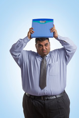 Sad obese man in formal clothes holding a weighing scale over his head