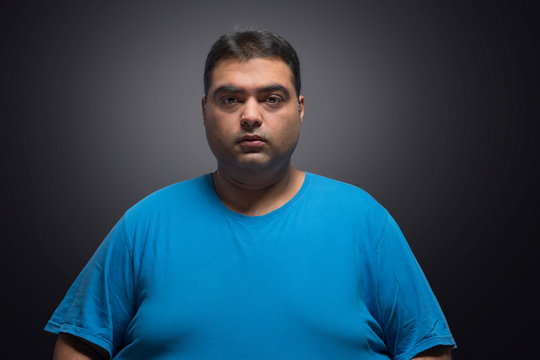 Portrait of fat man against a black background