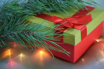 Christmas card.Gift under the tree and lights from the garland.