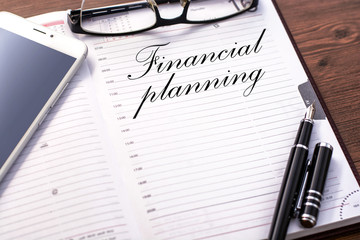 Fototapeta premium A business notebook (a diary) and business accessories (mobile phone, glasses, a fountain pen) with text Contact us.