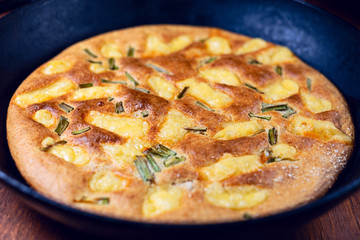 fried oatmeal pizza with cheese and spring onions in a frying pan