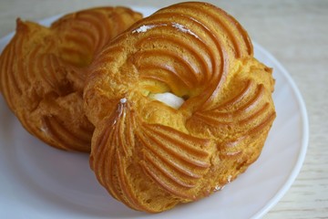 Delicious pastries.Choux pastry with cream on a white plate.