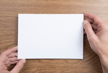 Mens hands holding empty white letterhead 