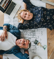 Couple lying on the wooden floor in their new house