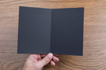 Obraz premium Mens hands holding black booklet