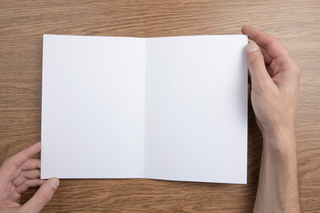 Fototapeta premium Mens hands holding white booklet