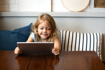 Little girl playing a game on a digital tablet
