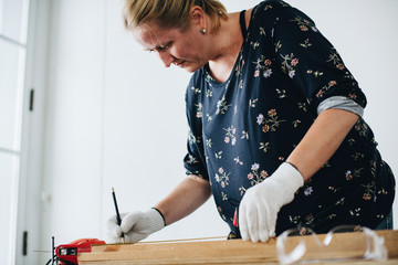 Woman measuring a wooden plank