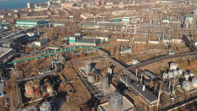 Aerial view of industrial factory or plant buildings with steel storage construction tanks and pipes, oil refinery and chemical manufacturing