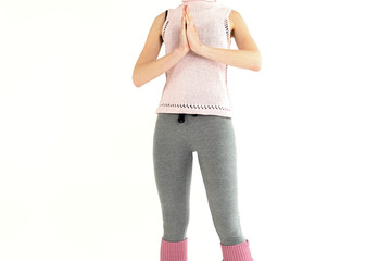 sporty slender girl in pink gaiters and gray leggings, doing namaste exercise yoga and gymnastics