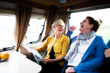 Cheerful elderly women discussing the newspaper