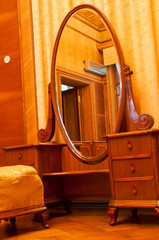Big antique mirror in a wooden frame on legs
