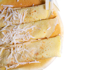 Pancakes rolled up in a tube with grated cheese are sprinkled