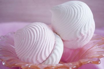 Vanilla and fruit marshmallows in a vase on a pink napkin.