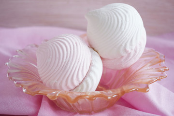 Vanilla and fruit marshmallows in a vase on a pink napkin.