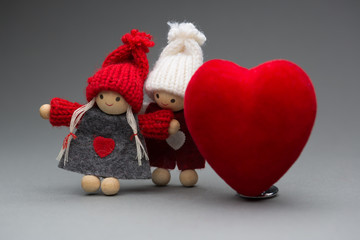 Two dolls in love on Valentines day knitted wear with heart postcard