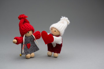 Two dolls in love on Valentines day knitted wear with heart postcard