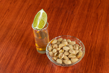 Golden tequila with lemon, pistachos, cacahuate, and salt. Drinks, Liquor