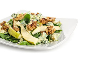 Delicious fresh salad with walnuts on plate, isolated on white