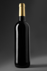 Bottle of red wine on grey background