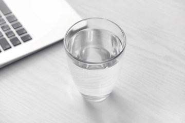 Glass of fresh water on white table