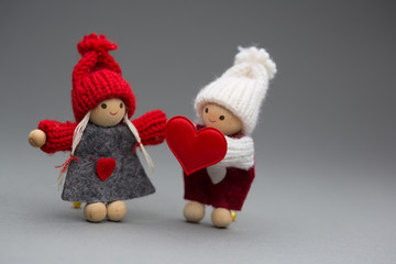 Two dolls in love on Valentines day knitted wear with heart postcard