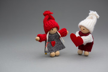 Two dolls in love on Valentines day knitted wear with heart postcard