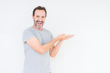 Handsome senior man over isolated background Pointing to the side with hand and open palm, presenting ad smiling happy and confident