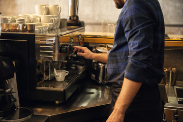 Barista preparing fresh aromatic coffee in cafe