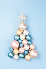 Christmas tree made of Christmas balls on blue background. Minimal New year concept.
