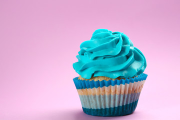 Tasty cupcake on color background