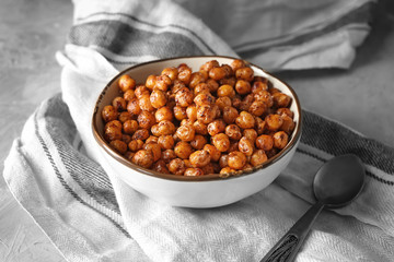 Bowl with fried chickpeas on table