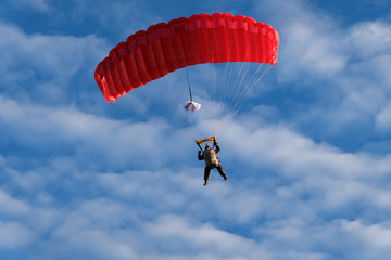 Red parachute is ib the sky.