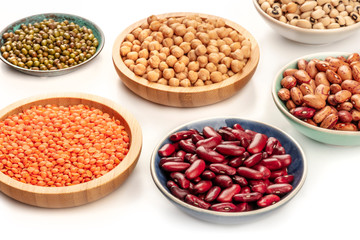 Fototapeta premium A photo of various types of legumes on a white background. Different beans, lentils, chickpeas, soybeans