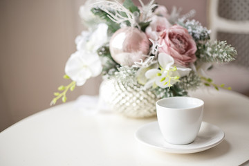 Obraz na płótnie Canvas white cup on a decorated coffee table
