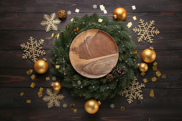 Composition with beautiful Christmas decorations and plate on wooden table