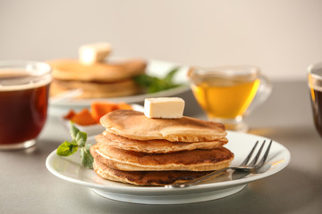 Stack of hot pumpkin pancakes with butter on plate