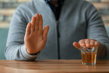 Man refusing to drink whiskey, closeup