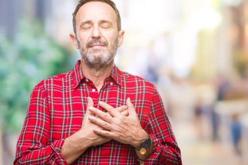 Obraz premium Middle age hoary senior man over isolated background smiling with hands on chest with closed eyes and grateful gesture on face. Health concept.