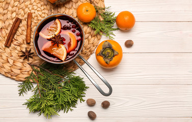 Pot of tasty mulled wine and ingredients on table