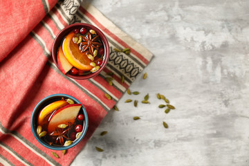 Cups of tasty mulled wine on light background