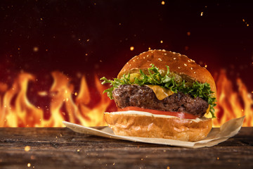 Delicious hamburger with fire on background © Jag_cz
