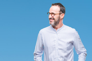 Middle age hoary senior man wearing glasses over isolated background looking away to side with...