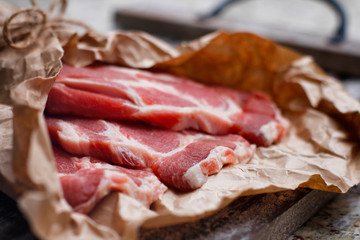 Fresh red chop meat on cooking paper. Dark red raw sliced meat on wooden table.