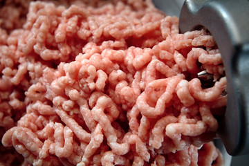 Minced meat coming out from grinder close-up. Healthy fresh homemade minced meat texture. Place for...