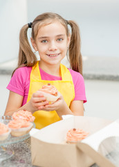Obraz na płótnie Canvas Smiling girl takes out the capcake from the gift box