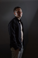 Fototapeta premium Portrait of determined goodlooking man wearing black shirt, black background.