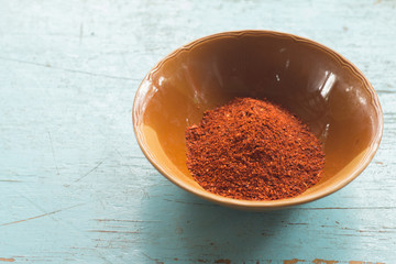 Red cayenne pepper on ceramic bolw on blue pastel wooden table background, Spicy Seasoning of Thai's food
