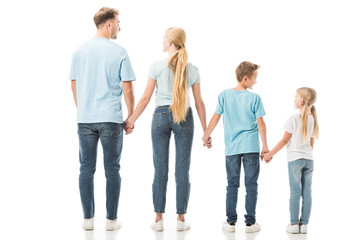Back view of family standing in jeans and holding hands isolated on white