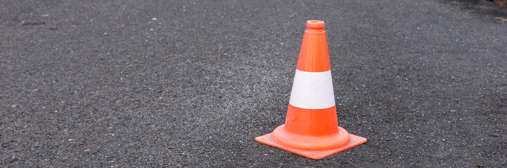 Red white road car safety cone on black asphalt